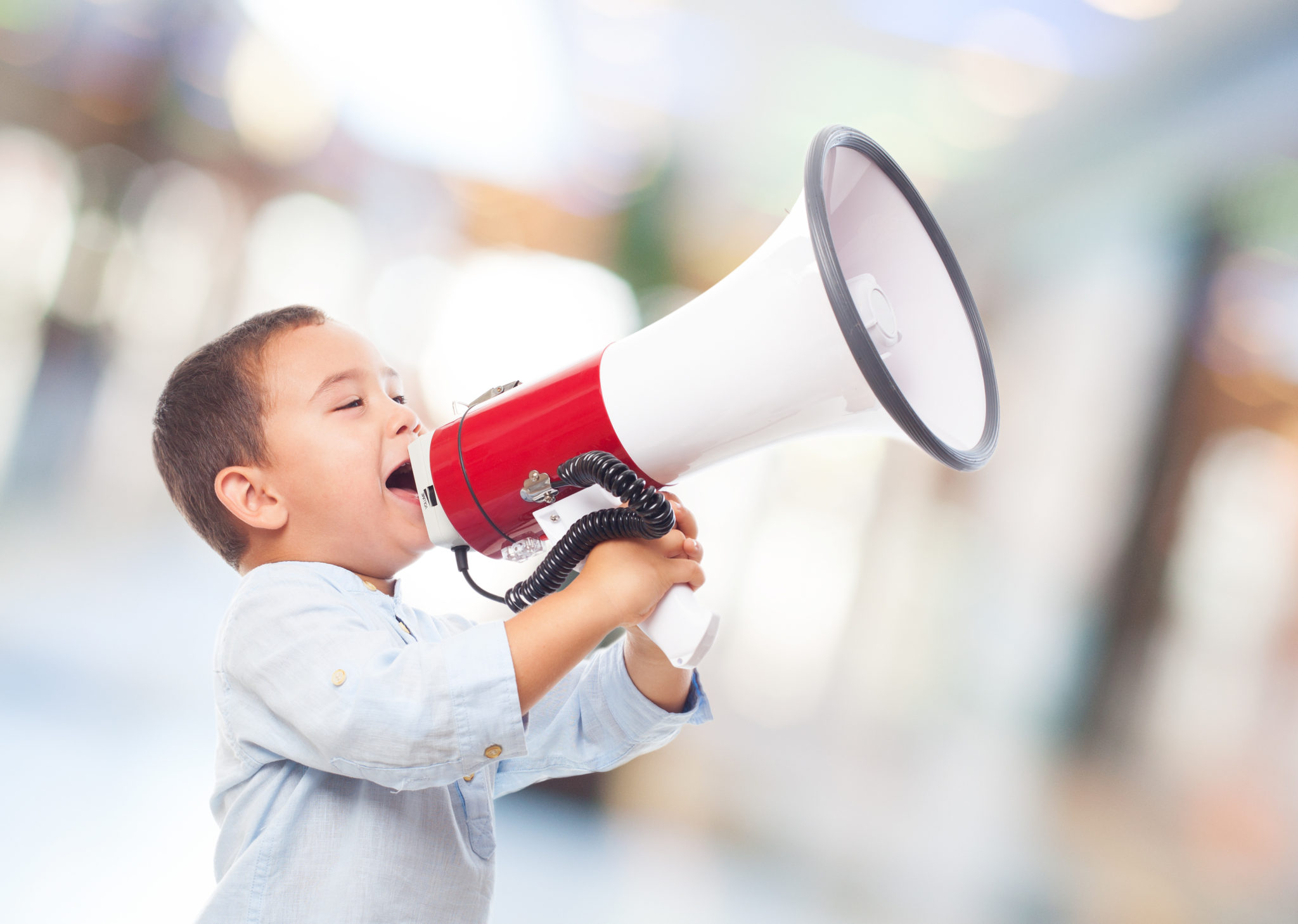 portrait of a little boy shouting on the megaphone